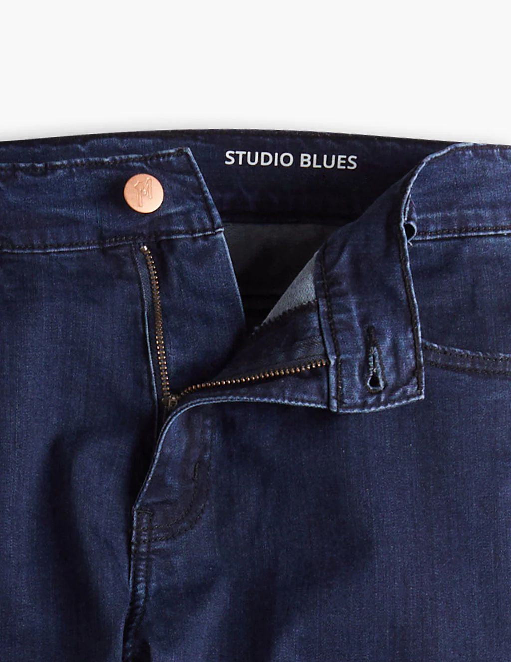 Dark indigo jeans waistband with label STUDIO BLUES, partially unzipped