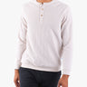A person wearing a light-colored henley shirt with buttons, standing against a white background.