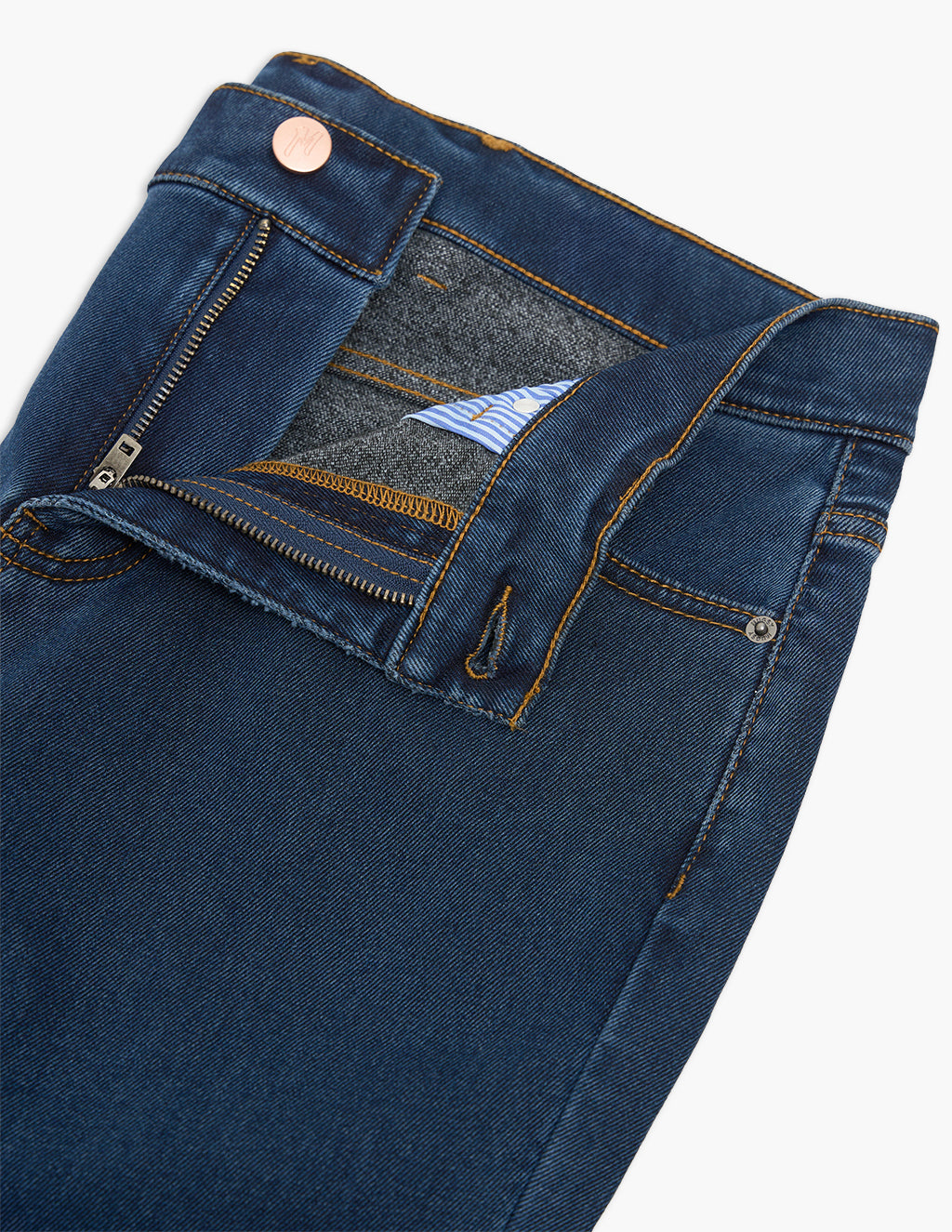 Close-up of dark blue jeans waistband and partly unzipped fly showing stitching, metal button, and striped pocket lining.