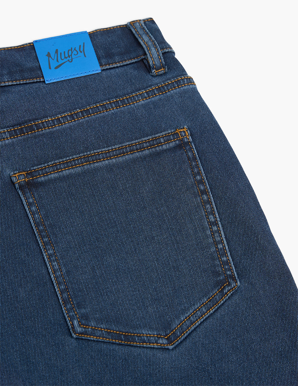 Back pocket detail of blue denim jeans with a blue label reading 'Mugsy'