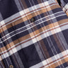 Navy, brown and white plaid flannel shirt close-up showing chest pocket and buttons.
