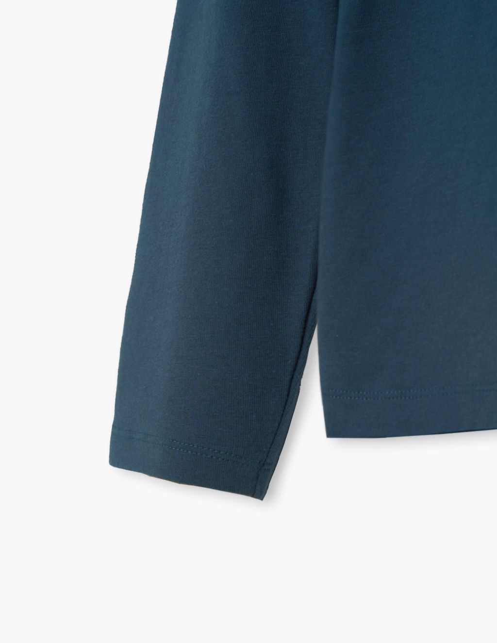 Close-up of a teal long-sleeve shirt showing sleeve, side seam and hem