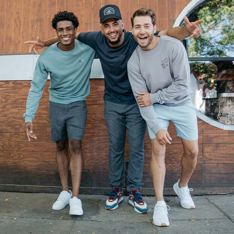 Three men in casual outfits, showcasing shorts and sweatshirts.