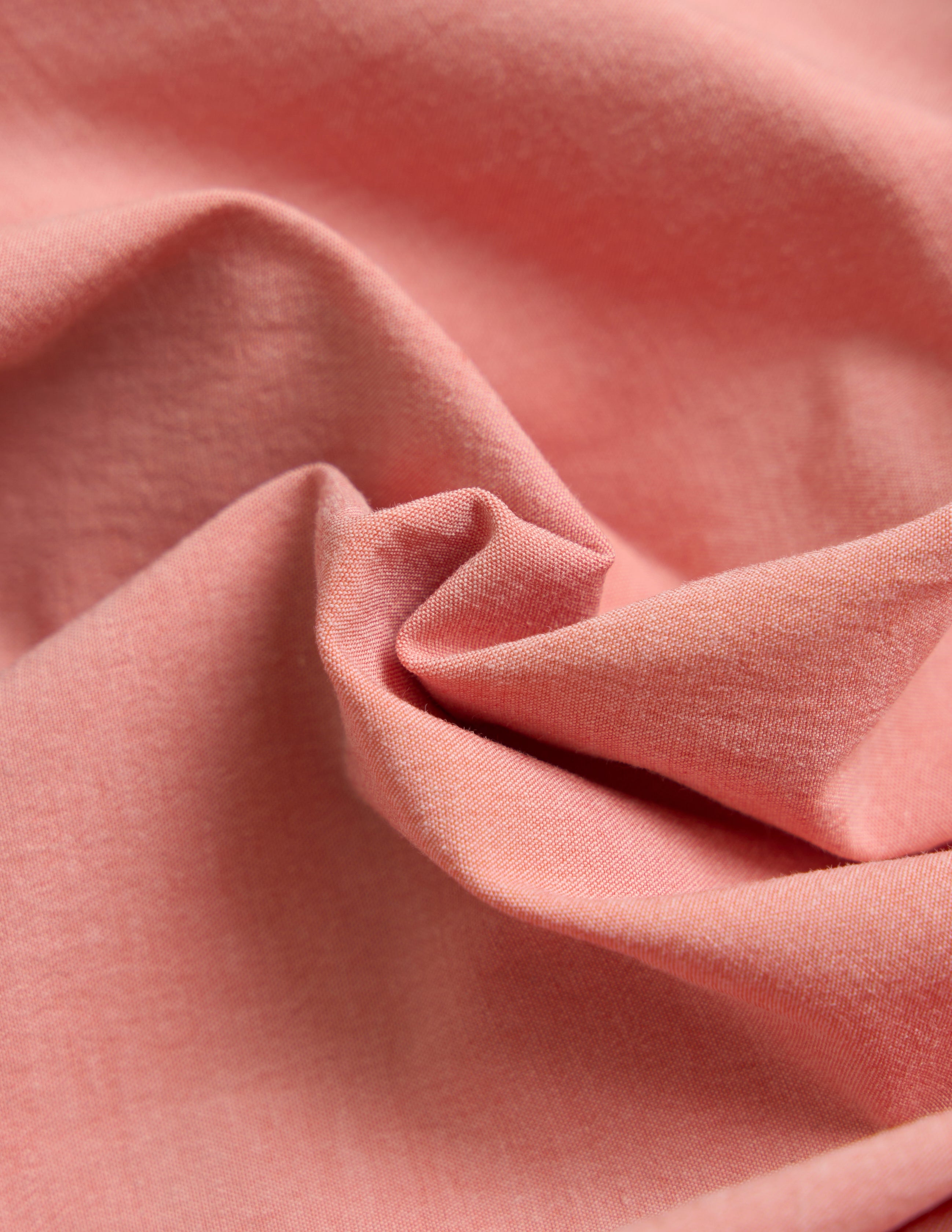 Close-up of pink fabric with visible folds and texture.