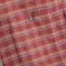 Red and orange plaid flannel shirt close-up showing pocket and brown button.