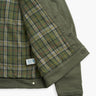 Olive jacket opened to reveal green, yellow and red plaid flannel lining with a small white brand tag near the hem.
