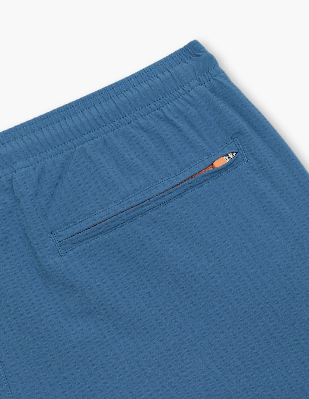 Back close up of Pacifics swim short showing textured blue fabric, elastic waistband and zippered pocket
