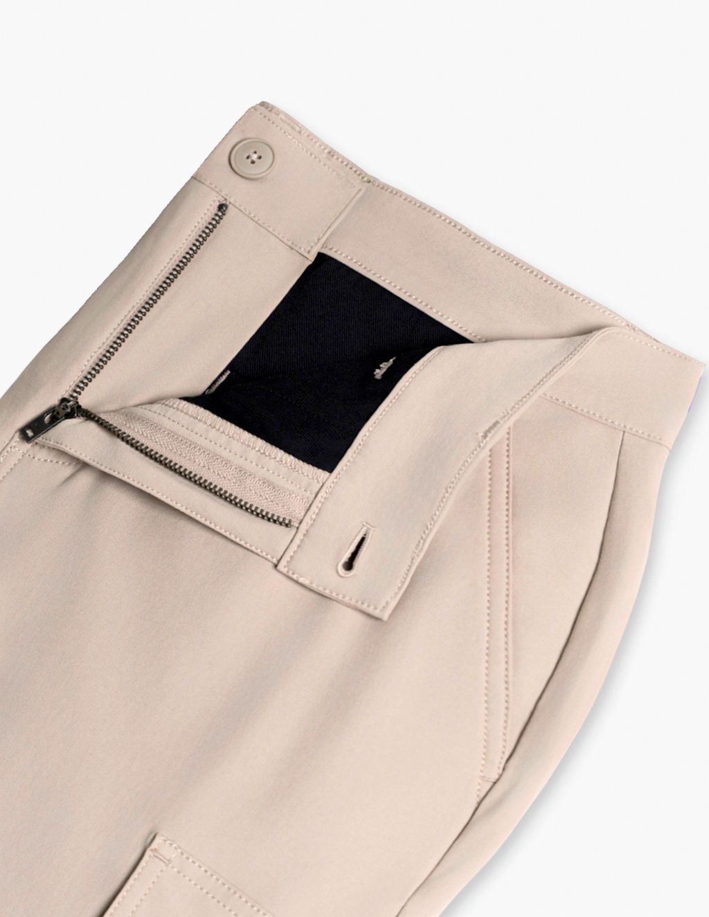 Beige trousers waistband with open fly revealing black lining, metal zipper, button, and front pocket.