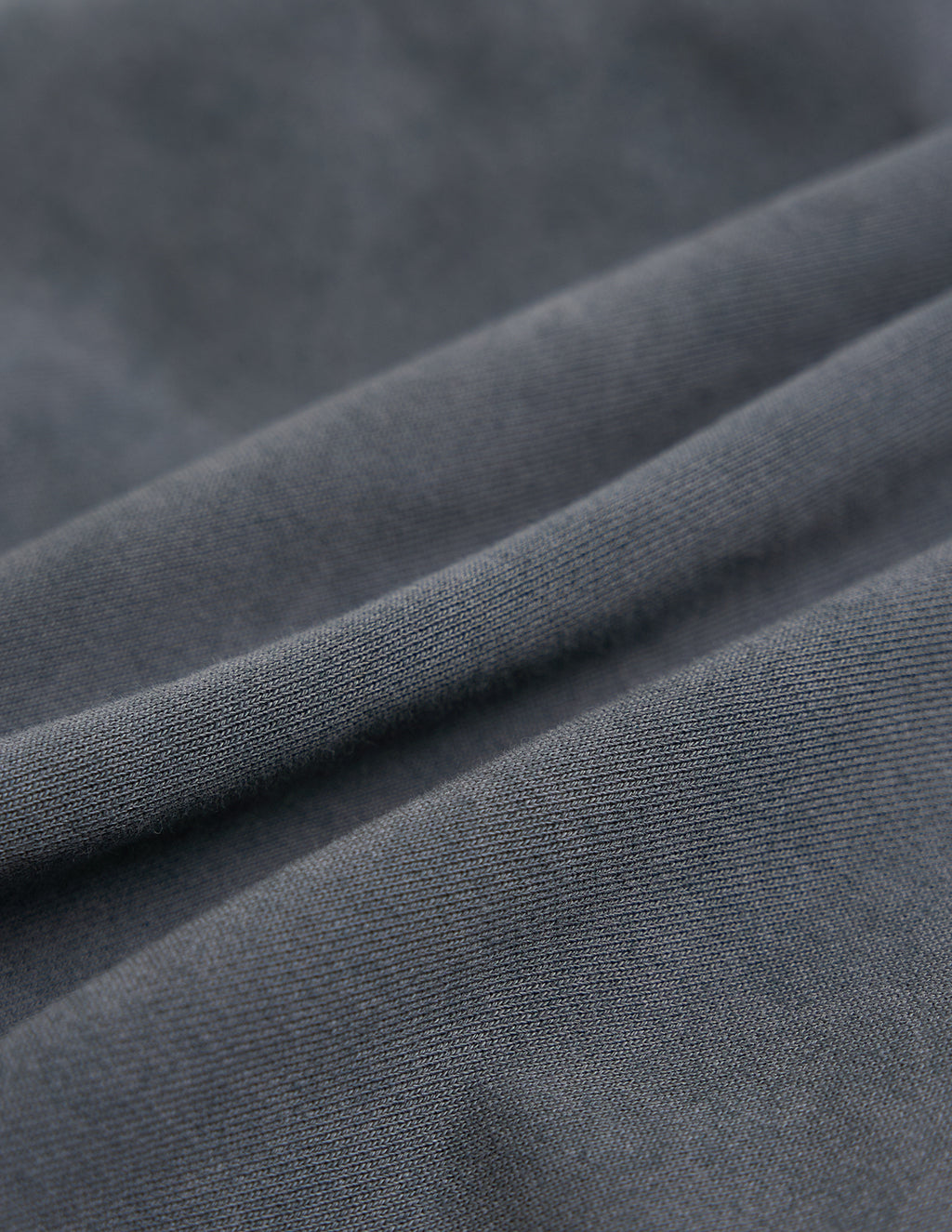 Dark gray knit fabric with soft folds and visible ribbed texture