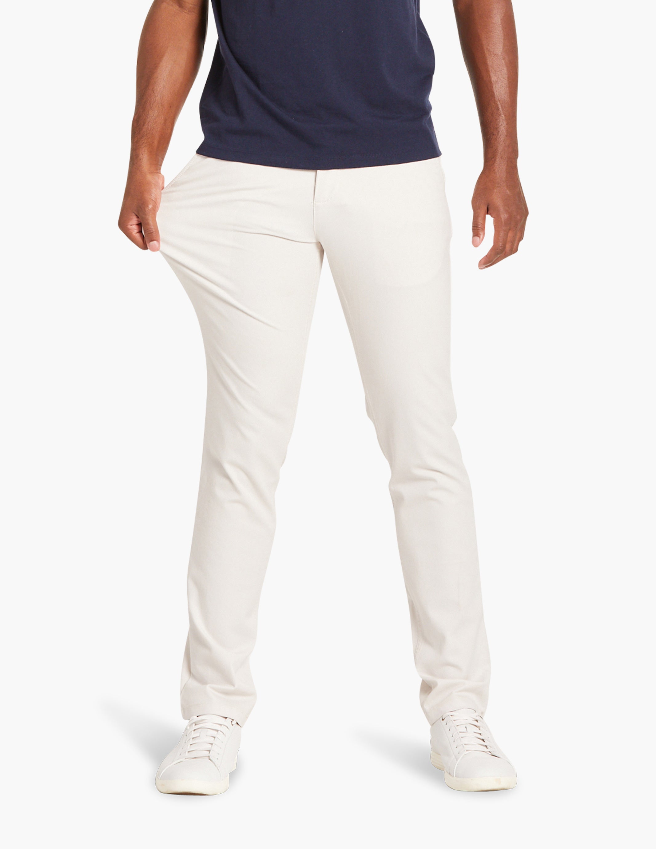 Model wearing off-white stretch chino pants with hands in pockets