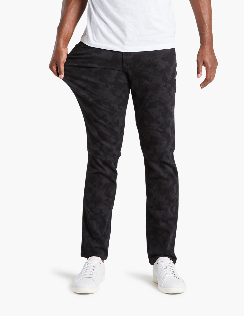 Model wearing black camo jeans, showcasing fit and style.