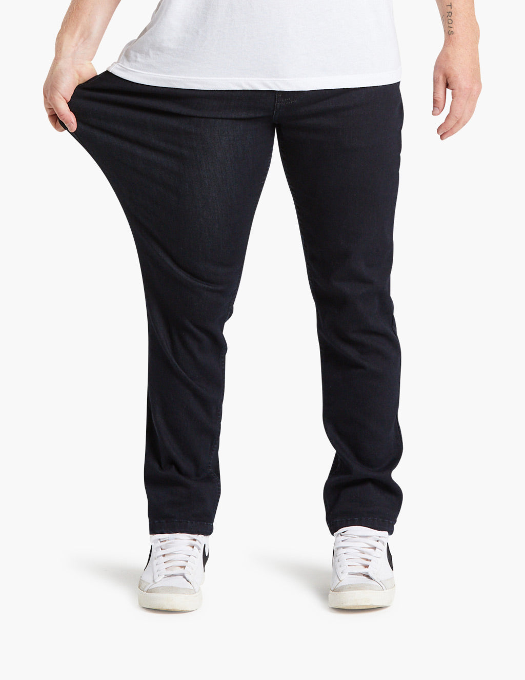Model stretching super dark blue stretch jeans, showcasing flexibility