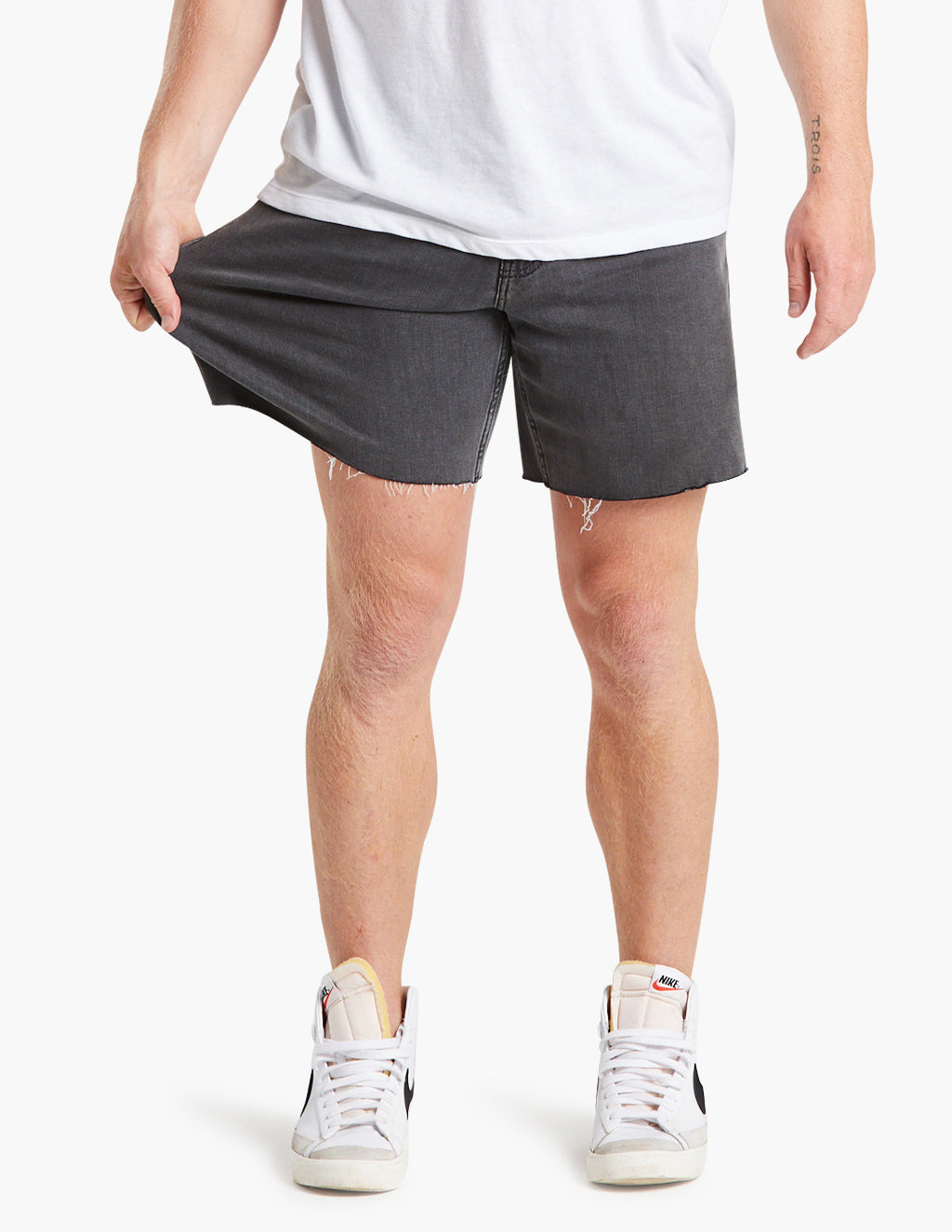 Model wearing gray black stretch denim jorts, showcasing fit and style.