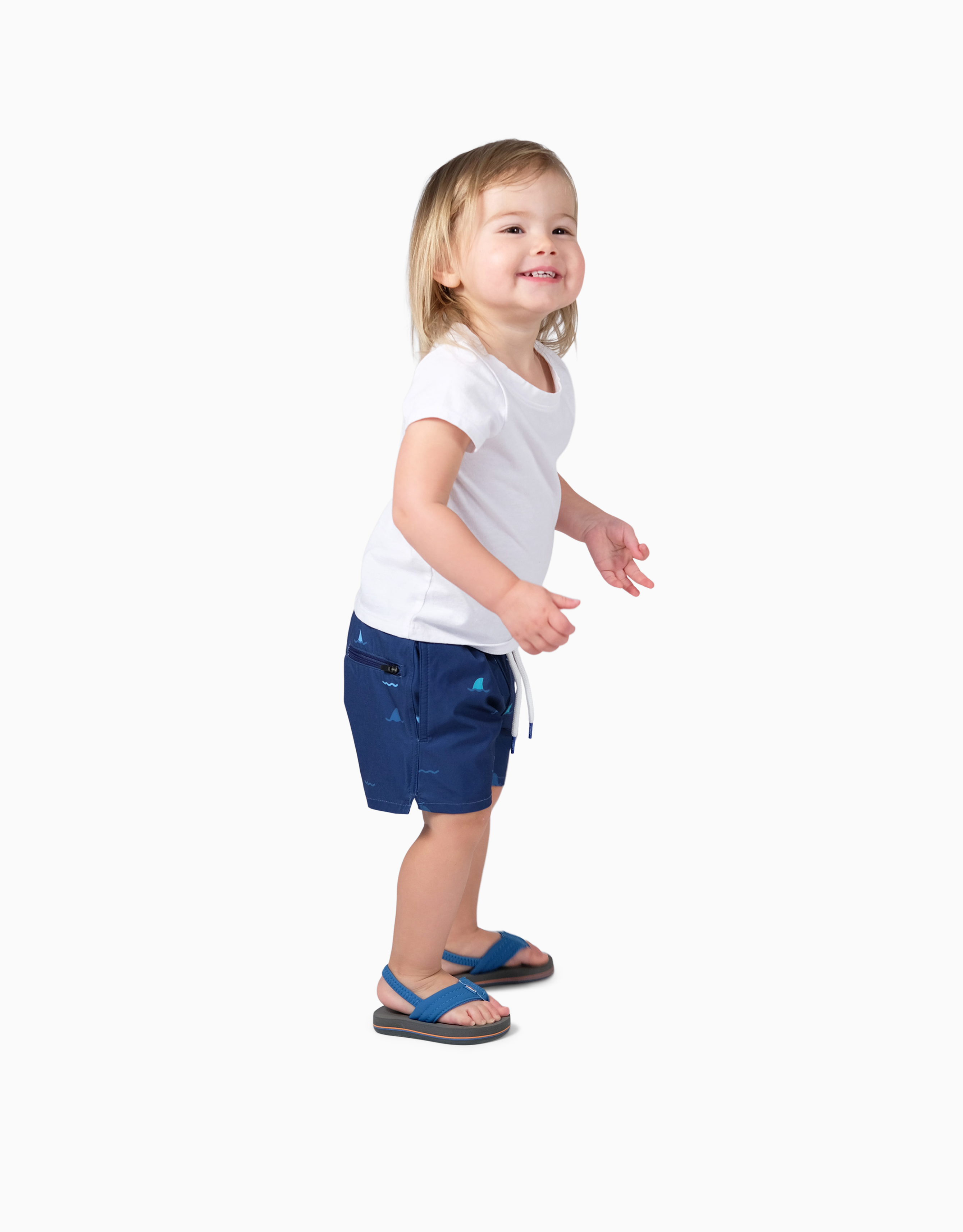 Child wearing navy swim shorts with sharks design