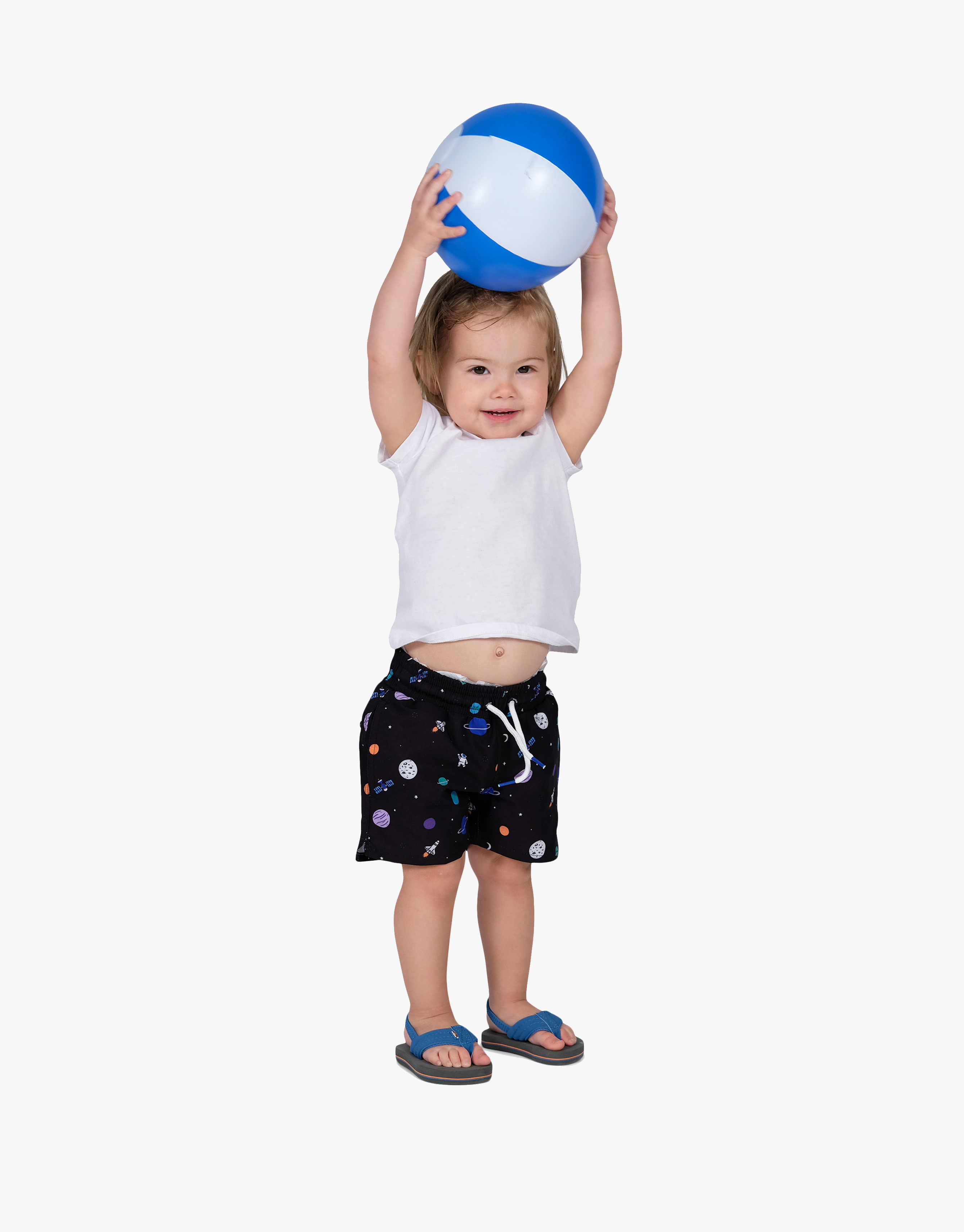 Child holding a beach ball, wearing black swim shorts with colorful patterns.
